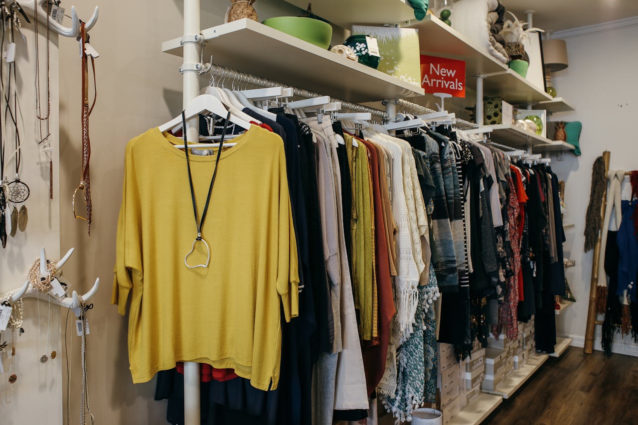 Home Interior of a fashion boutique with clothes elegantly displayed on racks and shelves.